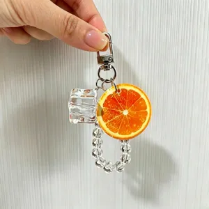 Detailed view of creative fruit keychain with realistic orange slice and ice cube