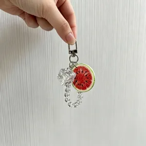 Detailed view of a watermelon slice and crystal bead keychain with an ice cube charm