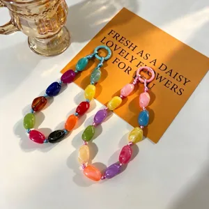 Detailed view of colorful irregular stone beaded phone charms with circular clasps.