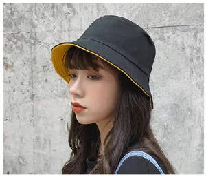 Detailed view of a double-sided cotton bucket hat in black and yellow for women