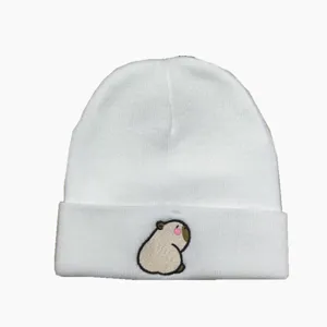 Détail de broderie mignonne de capybara sur un bonnet en tricot blanc pour femme