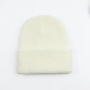Nahaufnahme der cremefarbenen Waffelstrickmütze mit dicker Textur und warmer Wolle.