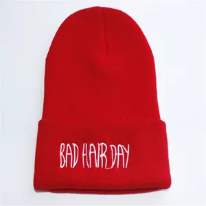 Detaillierte Nahaufnahme einer roten Strickmütze mit weißer 'BAD HAIR DAY' Stickerei