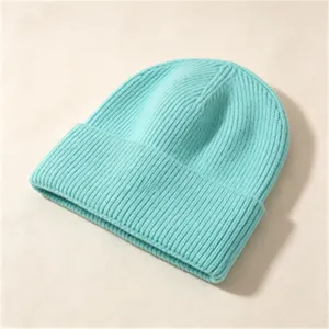 Detailansicht der dicken cyanfarbenen Rippstrickstruktur dieser warmen Wintermütze.