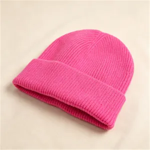 Detailansicht einer leuchtend pinkfarbenen Strickmütze mit weicher Wollgarntextur