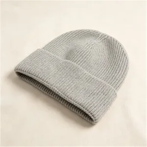 Nahaufnahme einer dicken grauen Strickmütze mit weicher Winterwolltextur für Damen