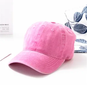 Detailansicht einer rosa gewaschenen Baumwoll-Baseballkappe mit Distressed-Struktur.