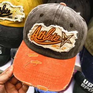 Nahaufnahme einer Vintage-Baseballkappe mit Athlete-Stickerei und orangefarbenem Schirm