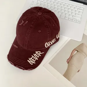 Detalle de gorra de béisbol granate estilo vintage con bordado Never Give Up