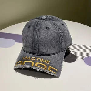 Detailansicht der gewaschenen Denim-Basecap mit Goldstickerei und Used-Look
