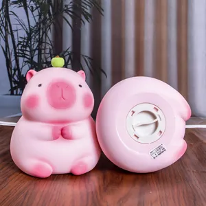 Detalle de una hucha de carpincho rosa con tapón de acceso en la base para monedas