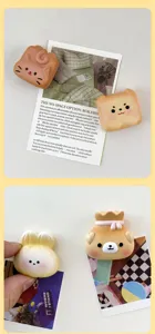 Close-up of cute animal-shaped resin fridge magnets on decorative polaroid cards.