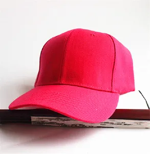 Nahaufnahme einer leuchtend pinkfarbenen Canvas-Baseballkappe mit Schirm auf weißem Grund.