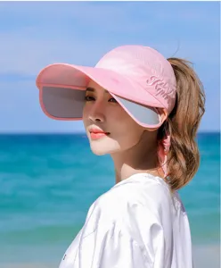 Seitenansicht eines rosa leeren Sonnenschutzvisiers mit ausziehbarem Rand am Strand
