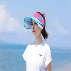Detail eines pink-blauen Sonnenvisiers für Damen mit breiter Krempe am Strand