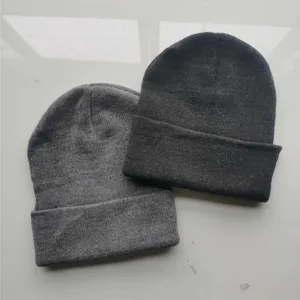 Détail des bonnets en tricot de polyester gris et noir, parfaits pour l'hiver.