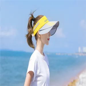 Seitenansicht einer Frau mit gelbem Sonnenvisier an einem sonnigen Strand