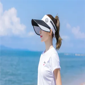 Detailansicht eines stylischen schwarz-weißen Sonnenvisiers am Strand-Model.