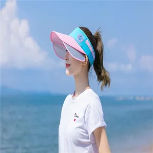 Schickes Damen-Sonnenvisier in Rosa und Blau mit ausziehbaren Seitenteilen am sonnigen Strand