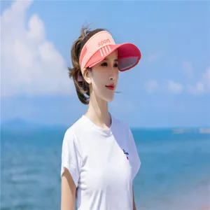 Asiatisches Model mit einem stylischen rosa Sport-Sonnenschutzhut am sonnigen Strand