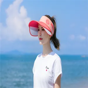 Detailaufnahme eines pinkfarbenen, ausziehbaren Damen-Sonnenschutzes an dem Strand