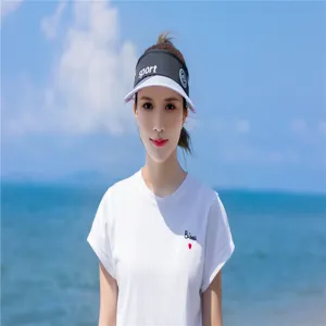 Asiatisches Model mit sportlicher schwarz-weißer Sonnenblende am Strand für Sonnenschutz