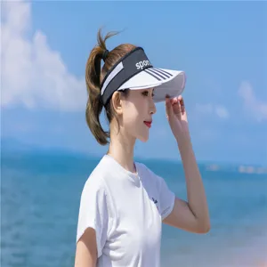 Asiatische Frau trägt einen stylischen Sonnenhut mit 'sport' Aufdruck am Strand