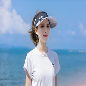 Damen Sonnenblende mit Sport-Print, getragen von einem Modell am sonnigen Strand
