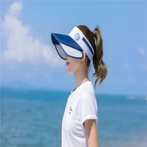 Seitenansicht einer Frau mit blau-weißem Sonnenvisier an einem sonnigen Strand