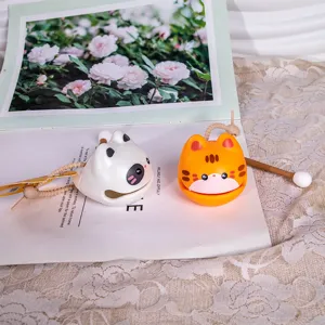 Primo piano di ciondoli a forma di pesce in legno a tema panda e gatto con martelletti.