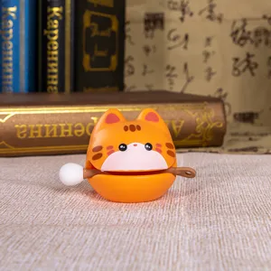 Primo piano di un simpatico ornamento a forma di gatto arancione Zen wooden fish con martello.