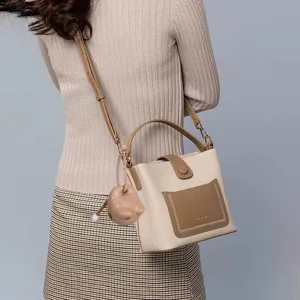 Vista dettagliata di un grazioso ciondolo a forma di pesce in legno su una borsa beige