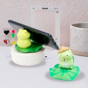 Close-up detail of creative frog and turtle phone stands on green lotus leaf bases