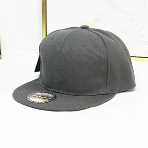 Detailansicht einer dunkelgrauen Snapback-Mütze mit flachem Schirm und holografischem Aufkleber.