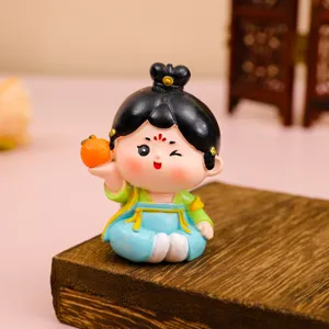 Gros plan d'une figurine de dame de la dynastie Tang tenant une petite orange sur bois