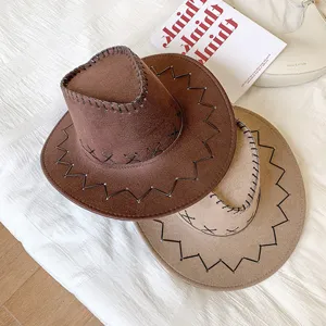 Dettaglio di due cappelli da cowboy in finta pelle scamosciata marrone e beige con cuciture