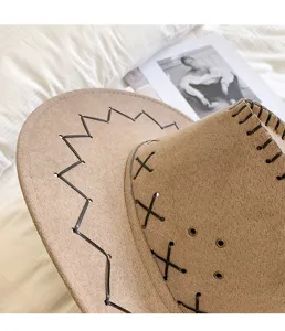 Dettaglio del cappello da cowboy in finta pelle scamosciata marrone con cuciture decorative