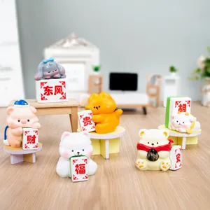 Primer plano de figuras de caja ciega de animales con fichas de Mahjong en una mesa.