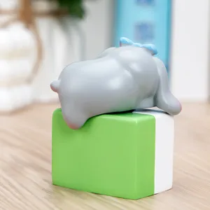 Vista detallada de una figura de elefante gris sobre un bloque de mahjong verde decorativo