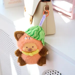 Lindo llavero de peluche con gorro de sandía colgado de un elegante bolso beige claro