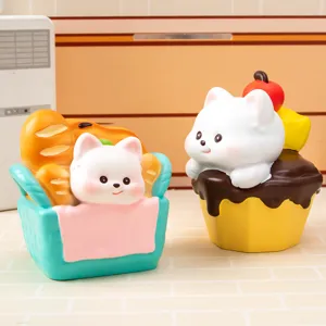 Gros plan de figurines Westie Bakery en résine montrant un chiot dans un panier et sur un cupcake