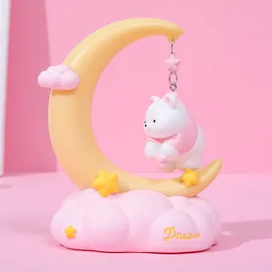 Creative pink and yellow crescent moon night light featuring a hanging white bear and stars