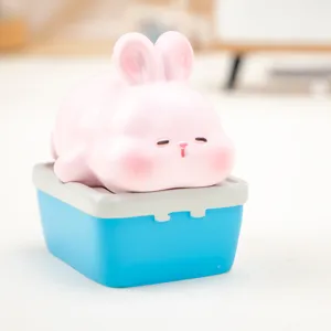 Close-up of cute pink Nini rabbit figurine on a blue miniature box storage case