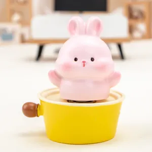 Detailed close-up of a cute pink rabbit resin figurine sitting in a bright yellow pot