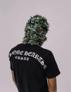 Detailansicht einer grünen Camouflage-Stricksturmhaube, die von einem Model getragen wird.