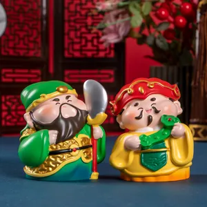 Primo piano di graziose figurine in resina Caishen e Guan Yu su una scrivania in stile cinese