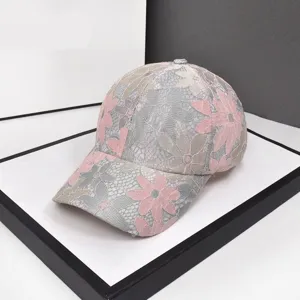 Dettaglio del ricamo floreale in pizzo su cappellino da baseball in mesh