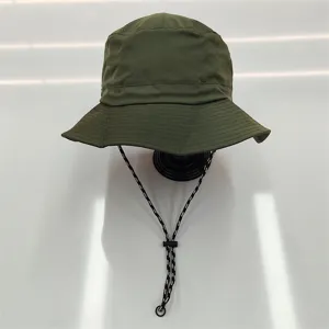 Detailed view of olive green waterproof bucket hat with adjustable black chin strap cord.