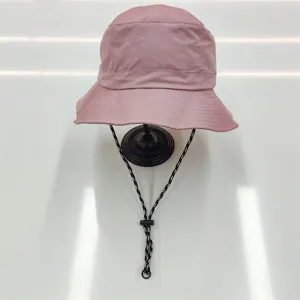 Detail view of a pink quick-dry bucket hat featuring an adjustable chin strap on a stand