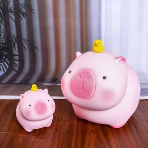 Primer plano de dos huchas de carpincho rosa con decoración de pato amarillo sobre madera